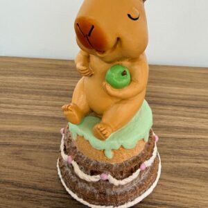 Capivara sentada no bolo de resina 17cm
